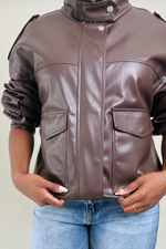 Brown leather jacket worn by a woman on a plain background