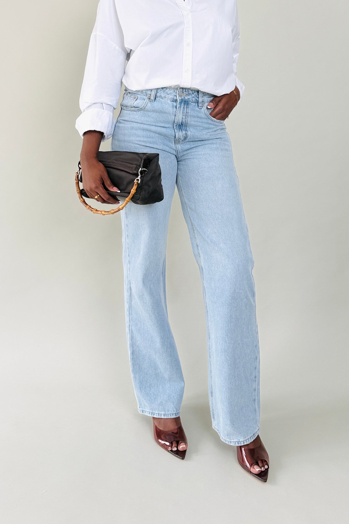 Tall woman wearing MODACCIO Livia Jean in light wash denim with white button-down shirt